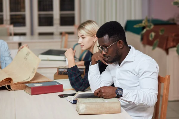 Bir grup üniversite kitaplığında kitaplarla eğitim çok ırklı insan. — Stok fotoğraf