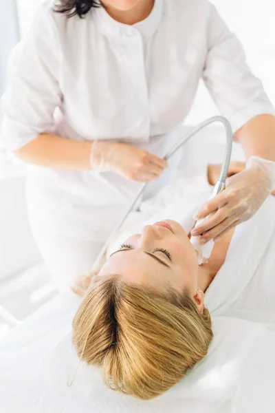 Donna che riceve un trattamento viso stimolante da un terapeuta — Foto Stock