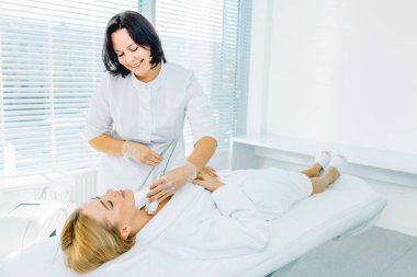 Bir gün güzellik Kliniği. Donanım kozmetik. Spa Kliniği. Cilt tedavi prosedürü güzel sarışın kadın. Sigara Cerrahi yüz germe. SMAS Facelift.