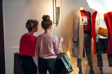 İki kadın kadınların önünde dikiz aynasından butik koleksiyonu yapıyor..