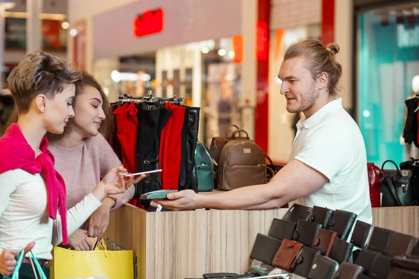 Женщина-клиент платит бесконтактной кредитной картой по технологии NFC в магазине. — стоковое фото