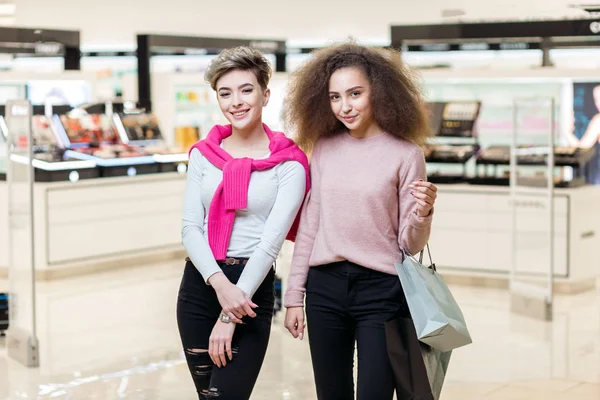 Twee beste vrienden collega meisjes poseren bij moderne winkelcentrum achtergrond — Stockfoto