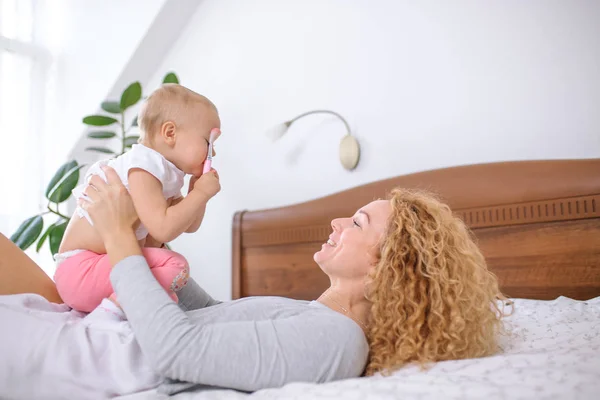 Alegre mujer divirtiéndose con su precioso bebé — Foto de Stock