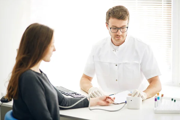 Gutaussehender Therapeut misst Herzpulse mit Blutdruckmessgerät, — Stockfoto