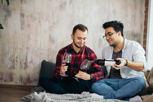 Riendo pareja gay macho bebiendo vino y preparando una comida — Foto de Stock