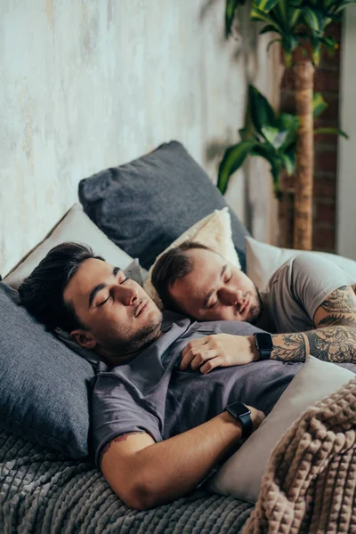 Δύο όμορφοι γκέι άντρες, γυμνοί στο κρεβάτι αγκαλιασμένοι και χαμογελαστοί ο ένας έχει ορατούς θωρακικούς και καθορισμένους κοιλιακούς. — Φωτογραφία Αρχείου