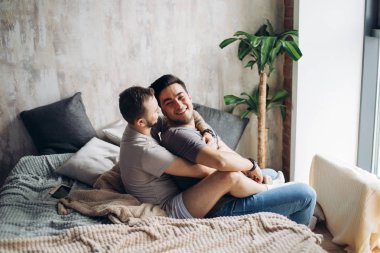 İki seksi beyaz gay sarılmış ve yatakta eğleniyor.