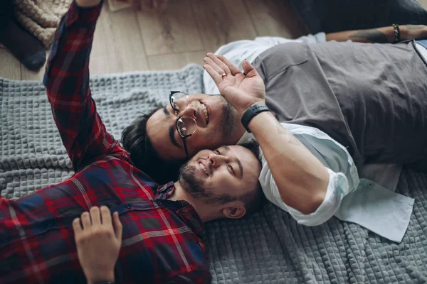Felice allegro caucasico gay coppia indossare casual vestiti fare selfie su letto — Foto Stock