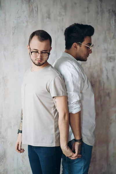 Dois homens chateados de pé de volta para trás isolado sobre fundo loft branco . — Fotografia de Stock