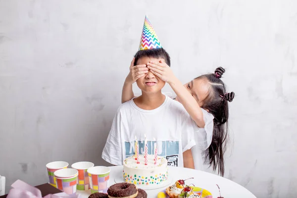 girl covering his friends eyes with hands to make a surprise