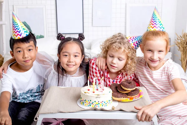 little nice children posing to the camera while sitting at the table