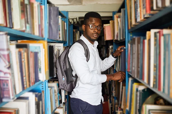 Afroamericano maschio college studen preparazione per gli esami in biblioteca . — Foto Stock