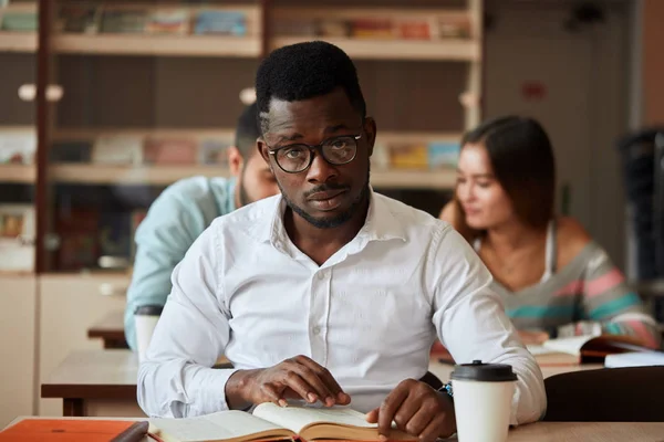 African american mężczyzna college studen przygotowujących się do egzaminów w bibliotece. — Zdjęcie stockowe