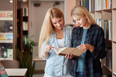 İki genç kız öğrenci shooses kitap kütüphane