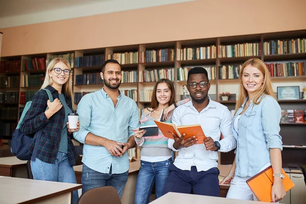 Mnohonárodnostní studenty baví v knihovně při přípravě na zkoušky. — Stock fotografie