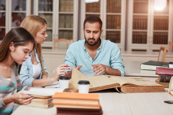 Grupo de personas multirraciales que estudian con libros en la biblioteca universitaria . — Foto de Stock