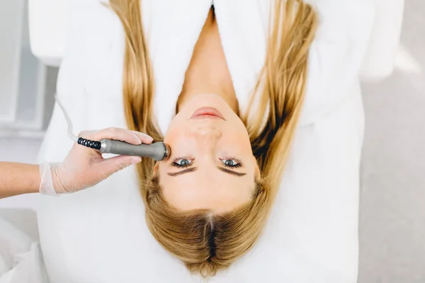 Blonde woman has ultrasonic dinamic lift massage in spa, hardware apparatus. — Stock Photo, Image