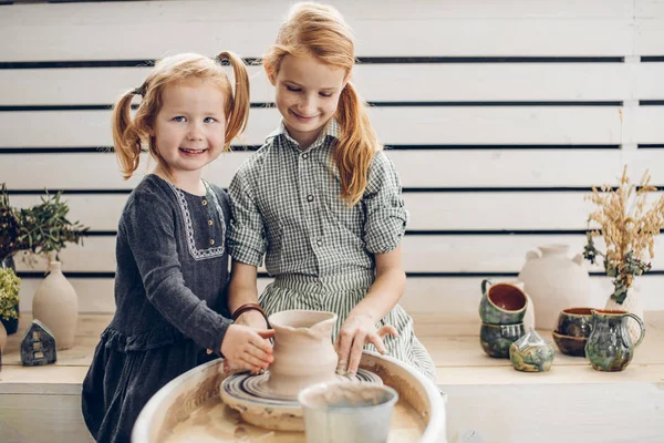 Niños sonrientes de pelo rojo usando la rueda de cerámica —  Fotos de Stock