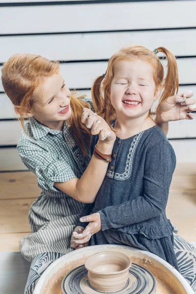Los niños se manchan unos a otros durante la lección de arcilla —  Fotos de Stock