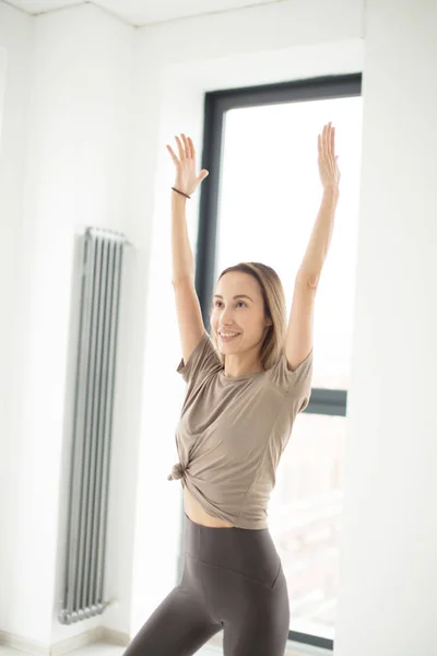 Smiling dancer with raised arms doing a movement — Stock Photo, Image
