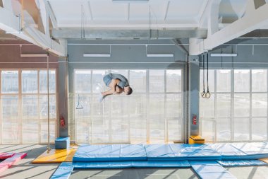 Flip yapan esnek adam paspasın üzerinde