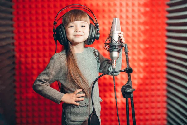 Leende glad tjej i hörlurar är bra på att sjunga — Stockfoto