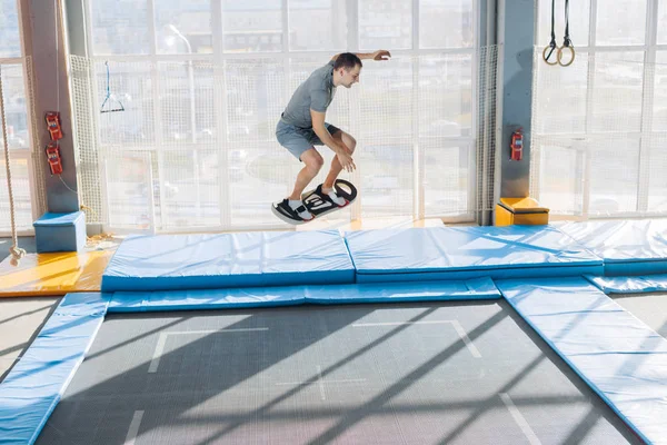 Cara incrível está fazendo acrobacias com bordo enquanto saltando — Fotografia de Stock