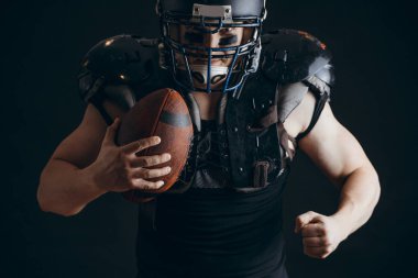 Kask takan ve koruyucu kalkan takan Amerikalı futbolcu.