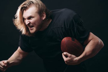 Kararlı Amerikan futbolcusu siyah arka planda izole edildi