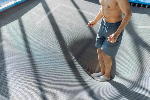 Cerca de foto recortada. hombre está probando el trampolín — Foto de Stock