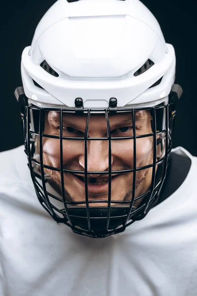 Portrait of sportsman in hockey uniform over black background