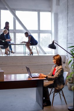 Birlikte çalışma alanında çok ırklı başarılı bir bayan takım. Açık Alan ofisi