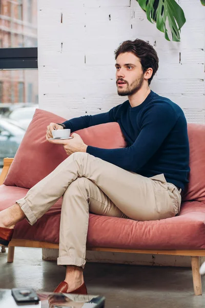 stylish attractive man is drinking coffee during the break