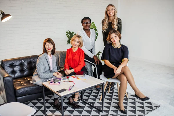 Dames van de jonge bedrijf van verschillende rassen poseren samen op witte achtergrond — Stockfoto