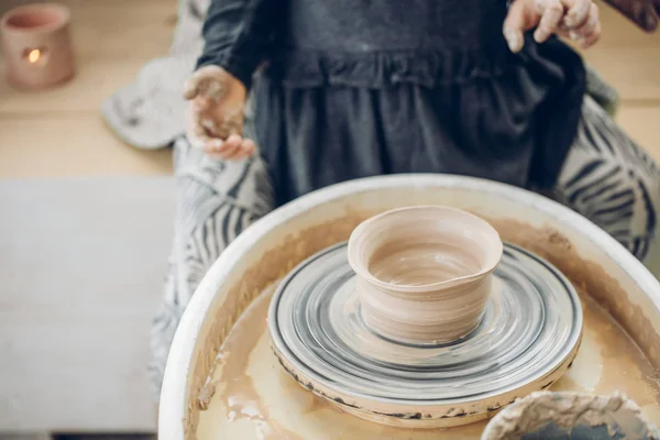 Keramikwerkstatt. die Frau macht einen Topf aus Ton auf einer Töpferscheibe. — Stockfoto