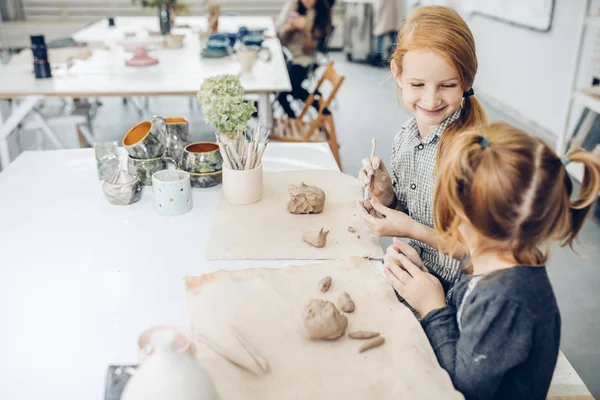 Крупним планом фото щасливих дітей розважаються в глиняній студії — стокове фото