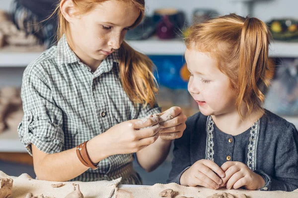 two ginger adorable girl making a shape to a product