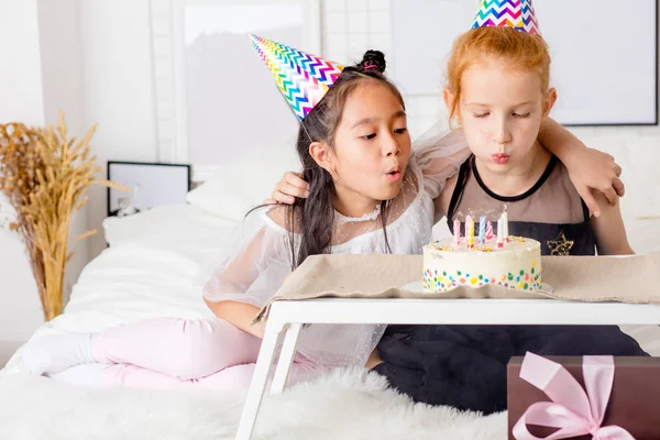 Niñas soplando velas en pastel de cumpleaños —  Fotos de Stock