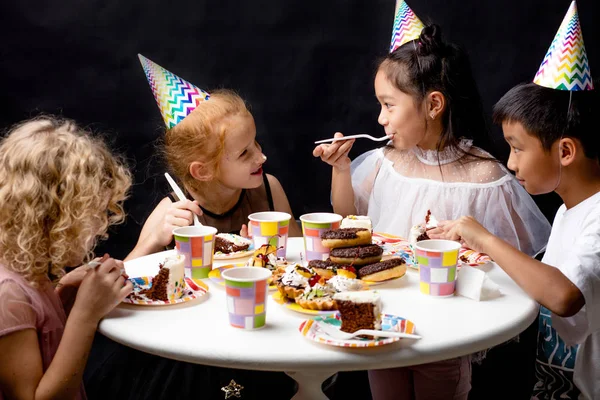 Les enfants mangent et profitent ensemble de la fête d'anniversaire intérieure — Photo