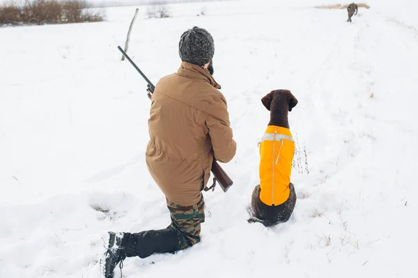 Vista trasera. un cazador y un perro están listos para disparar al animal — Foto de Stock