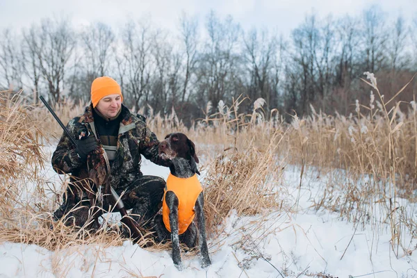 Κυνηγός και το σκυλί είναι μέσα στο δάσος του χειμώνα — Φωτογραφία Αρχείου