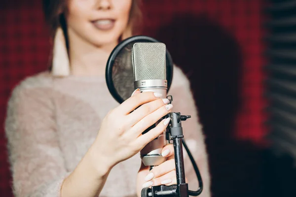 Attraente ragazza tenendo microfono stand in studio — Foto Stock