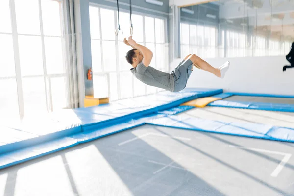 Sportieve man, springen en dowwn op de trampoline — Stockfoto
