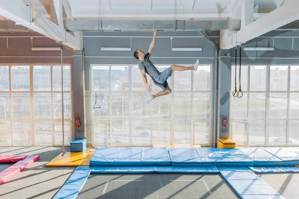 Hombre divertido tratando de tocar el techo durante el salto —  Fotos de Stock