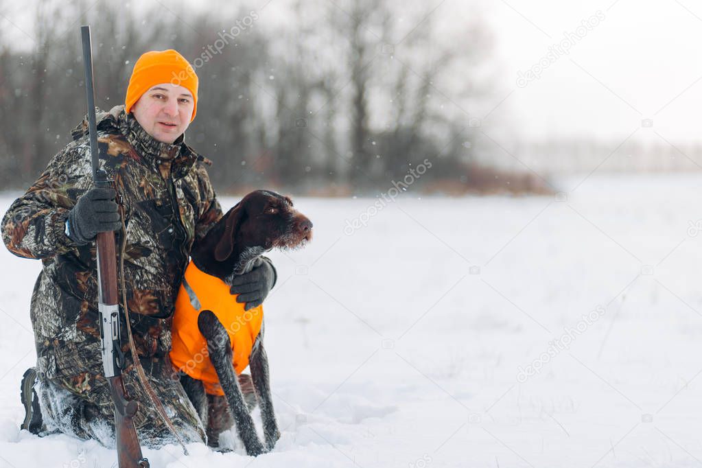 pleasant young Caucasian hunter with gun and dog spending time outdoors