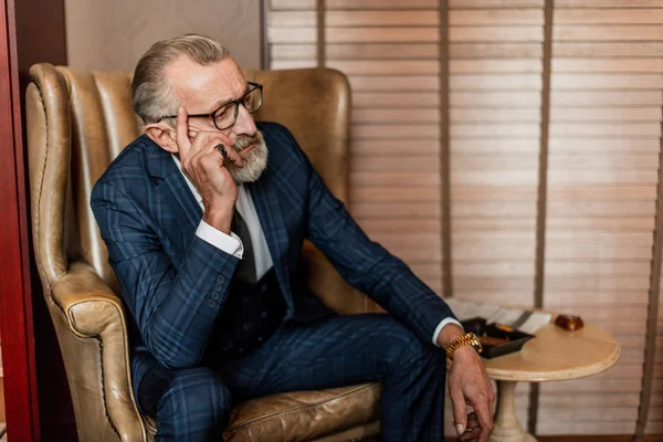 Homem de negócios idoso em terno formal com uísque e charuto no lux — Fotografia de Stock