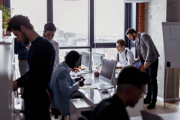 Gente de negocios en un espacio abierto oficina interior con una ventana panorámica — Foto de Stock