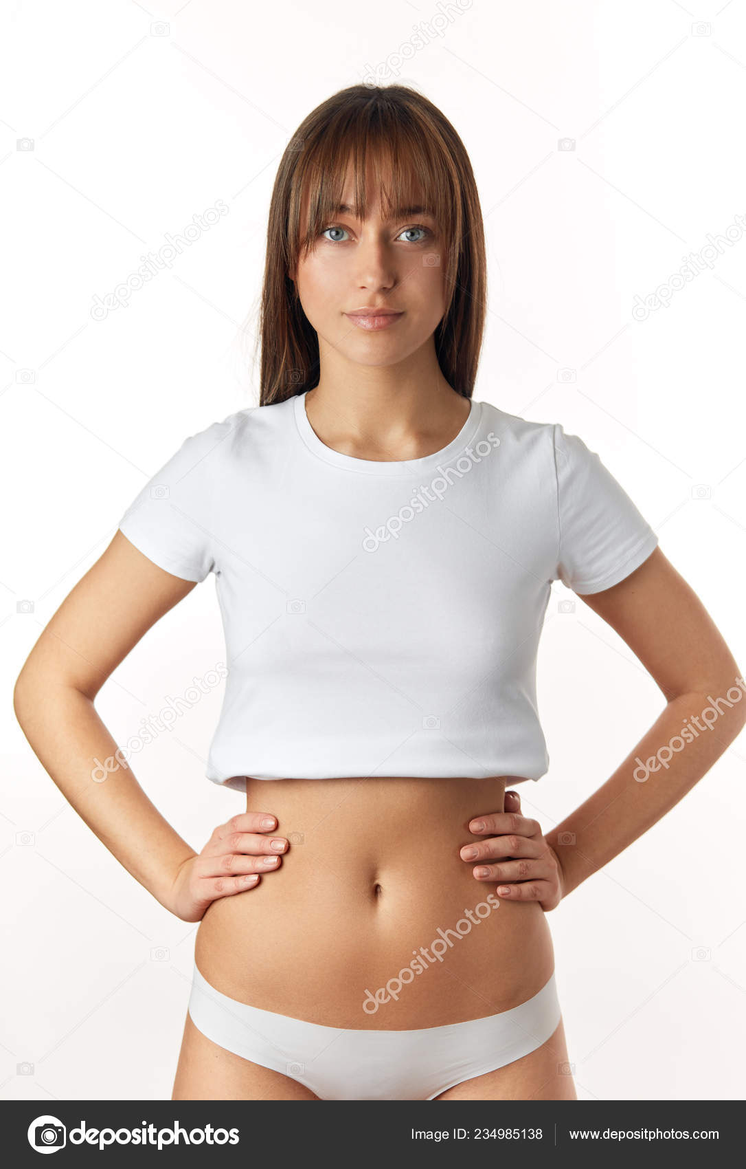 Beautiful Young Woman Dressed In White Top And Panties Shows Her Slim Body  And Flat Tummy. Girl With Perfect Body Shape, Flat Belly In Underwear.  Health, Hygiene Concepts. Stock Photo, Picture and