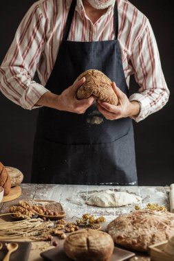 Tanınmayan baker taze pişmiş rustik organik somun ekmek elinde tutan