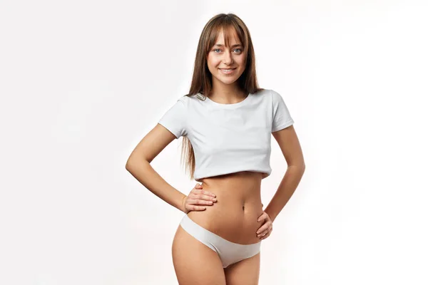 Attraktive junge Frau in weißer Unterwäsche posiert vor weißem Hintergrund — Stockfoto